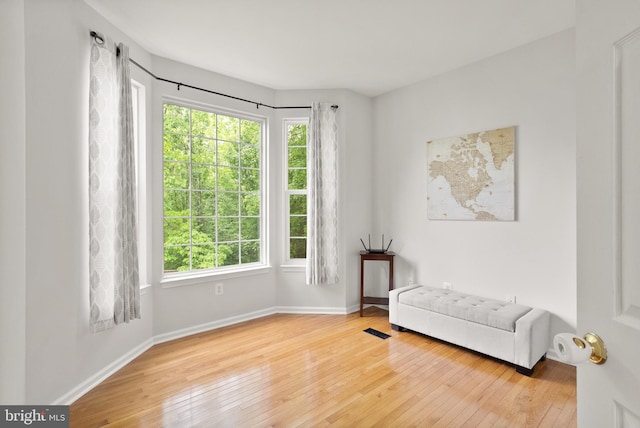 living area with hardwood / wood-style flooring, baseboards, and visible vents