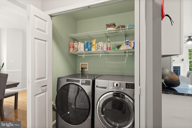 laundry room with laundry area, wood finished floors, and washer and dryer