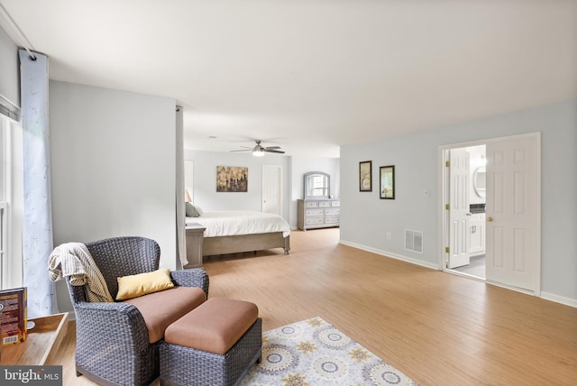 bedroom featuring baseboards, visible vents, wood finished floors, and a ceiling fan
