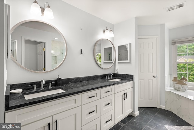 bathroom with marble finish floor, visible vents, a sink, and double vanity