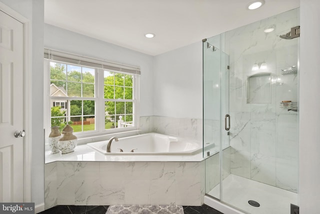 bathroom featuring a bath, a marble finish shower, and recessed lighting