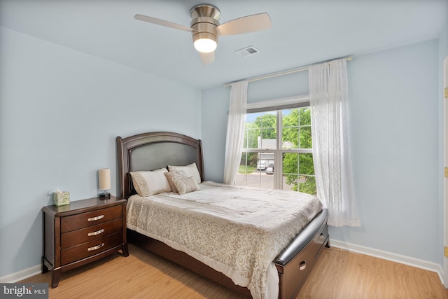 bedroom featuring light wood-style floors, visible vents, baseboards, and a ceiling fan