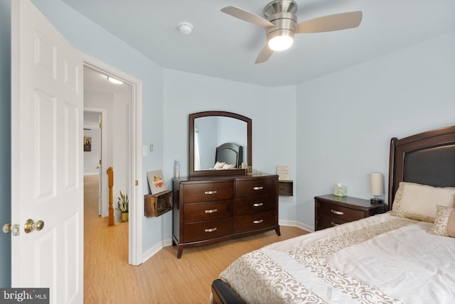 bedroom with light wood-style flooring, baseboards, and a ceiling fan