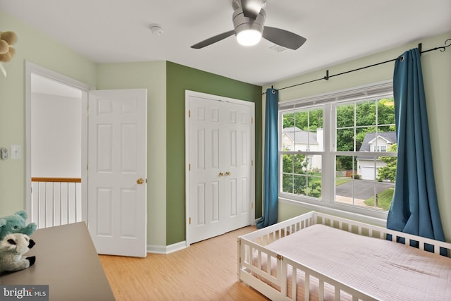 bedroom featuring baseboards, a closet, a ceiling fan, and wood finished floors
