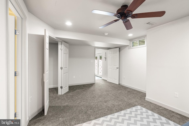 below grade area with a healthy amount of sunlight, ceiling fan, carpet flooring, and visible vents