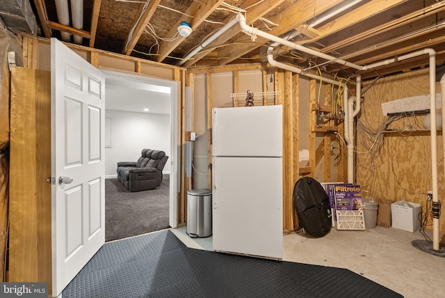 unfinished basement with freestanding refrigerator
