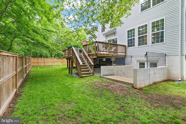 view of yard with stairway, a deck, and a fenced backyard