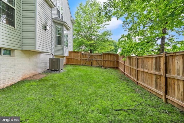 view of yard with cooling unit, a gate, and a fenced backyard