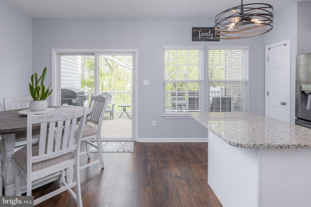 dining space with baseboards and dark wood-style floors