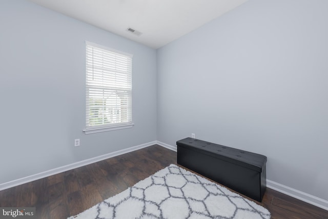 bedroom featuring baseboards, wood finished floors, and visible vents