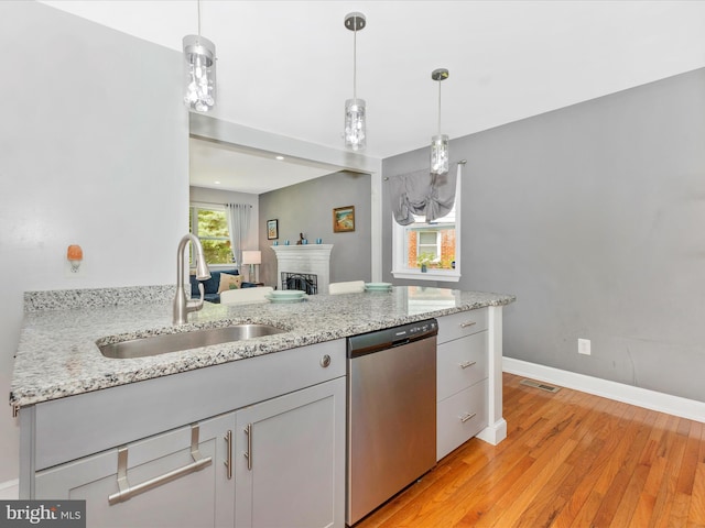 507 Kerwin Ct, Silver Spring, MD 20901 - kitchen with stainless steel dishwasher, a sink, light wood-style floors, a fireplace, and baseboards