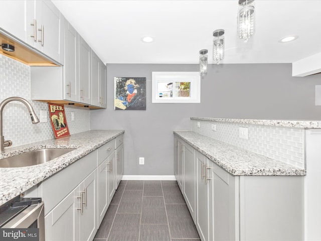 507 Kerwin Ct, Silver Spring, MD 20901 - kitchen featuring a sink, backsplash, a peninsula, baseboards, and light stone countertops