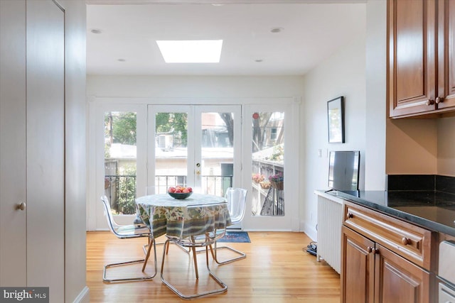 dining area featuring a skylight and light wood-style flooring