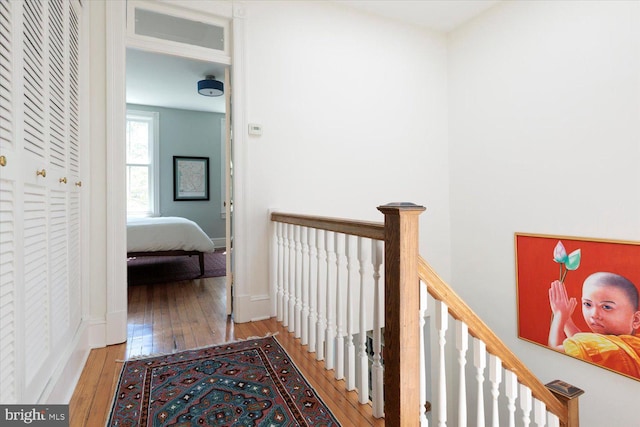hall featuring hardwood / wood-style flooring and an upstairs landing