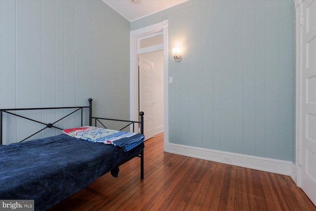 bedroom with baseboards and hardwood / wood-style flooring