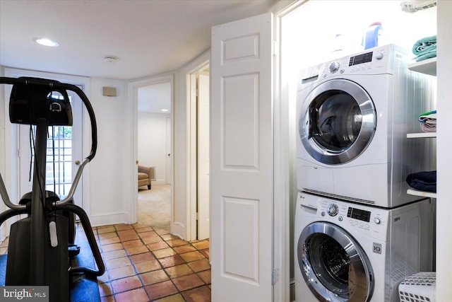 laundry room featuring stacked washer and dryer, laundry area, and baseboards