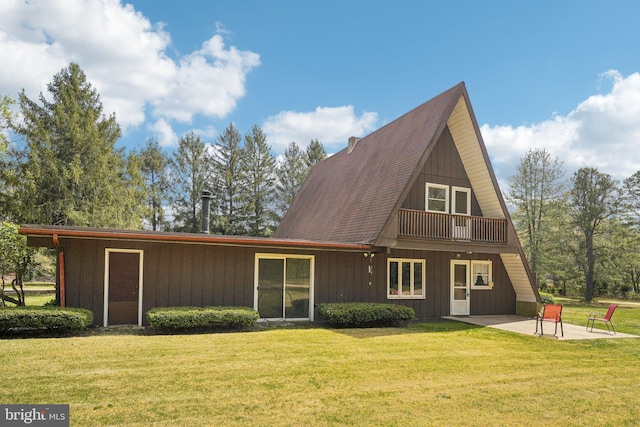 rear view of house with board and batten siding, a patio area, and a yard