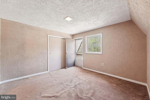 unfurnished bedroom featuring a textured wall, a textured ceiling, and visible vents
