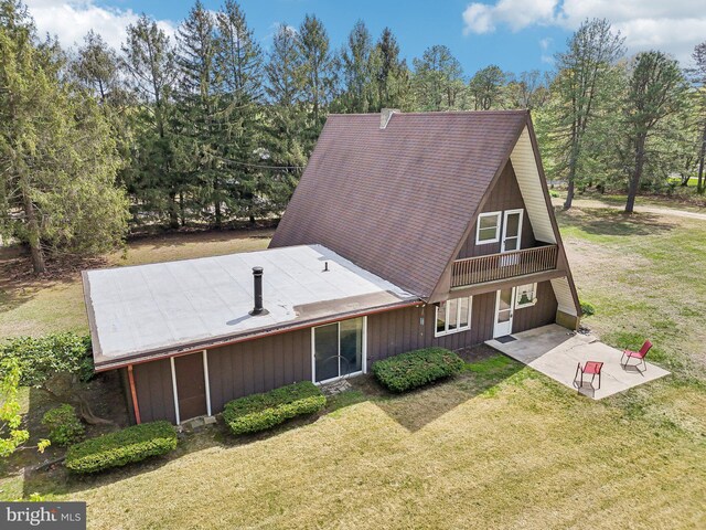 back of house with a yard and a patio