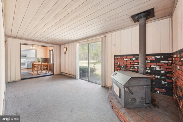 interior space featuring a baseboard heating unit and a wood stove