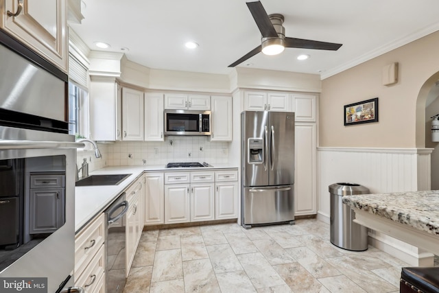40 Treaty Elm Ln, Haddonfield, NJ 08033 - kitchen featuring arched walkways, appliances with stainless steel finishes, a wainscoted wall, a sink, and a ceiling fan