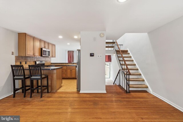 18 University Mews, Philadelphia, PA 19104 - kitchen with baseboards, a peninsula, and appliances with stainless steel finishes