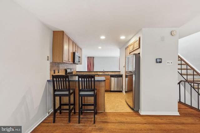 18 University Mews, Philadelphia, PA 19104 - kitchen with light wood-type flooring, a sink, a peninsula, stainless steel appliances, and recessed lighting