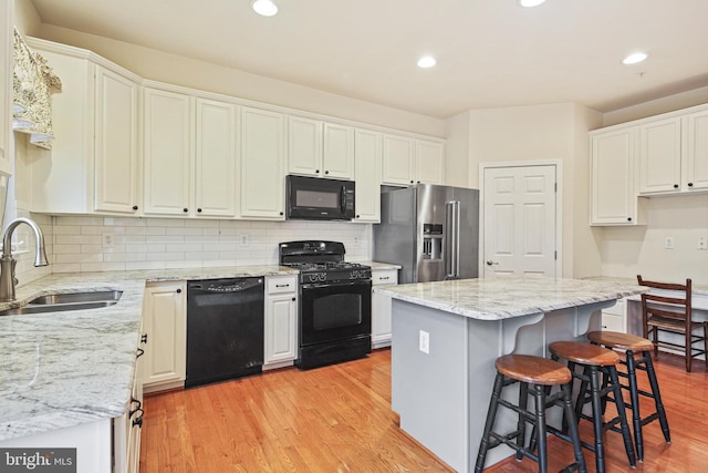 7601 Willow Bottom Rd, Sykesville, MD 21784 - kitchen with a sink, light wood finished floors, white cabinetry, and black appliances