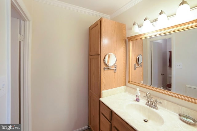 bathroom featuring toilet, ornamental molding, and vanity