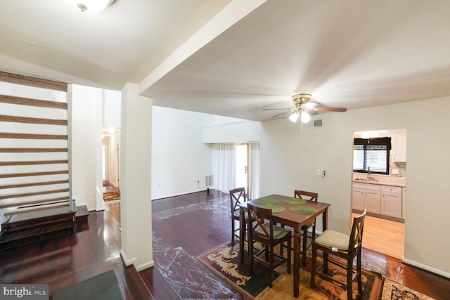 dining room featuring dark wood-style flooring, ceiling fan, and visible vents