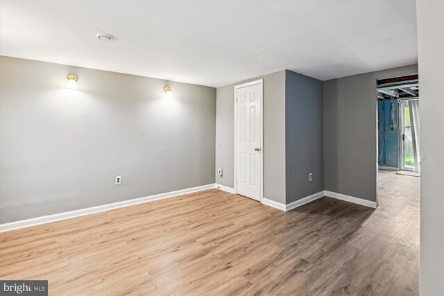 basement with baseboards and wood finished floors