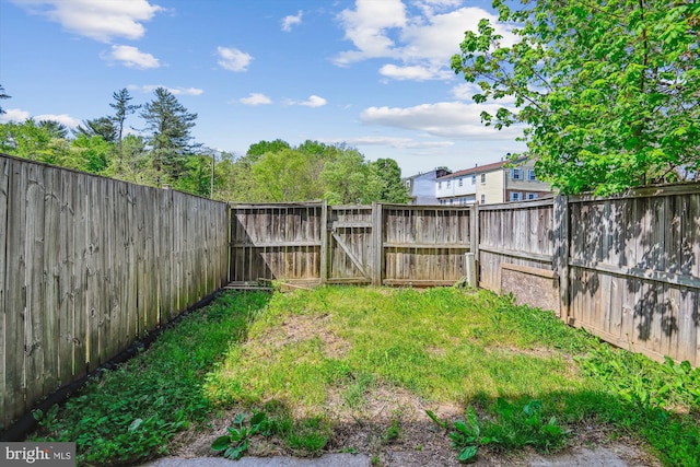 view of yard with a gate and a fenced backyard