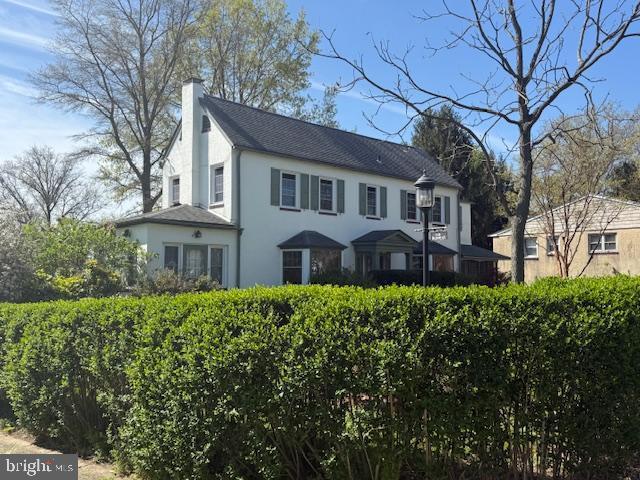 view of front of house featuring a chimney and stucco siding