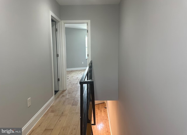 hallway featuring baseboards and light wood finished floors
