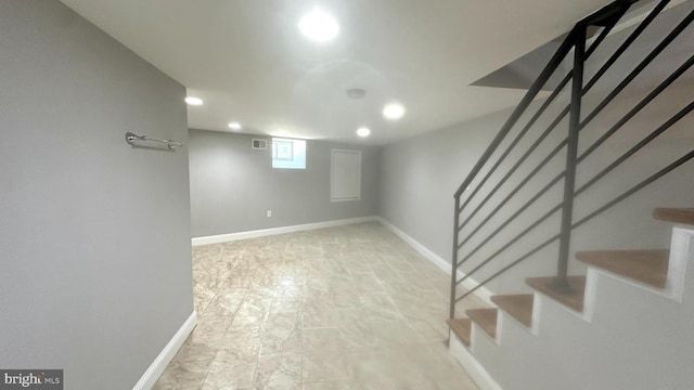 below grade area with baseboards, recessed lighting, stairs, and visible vents