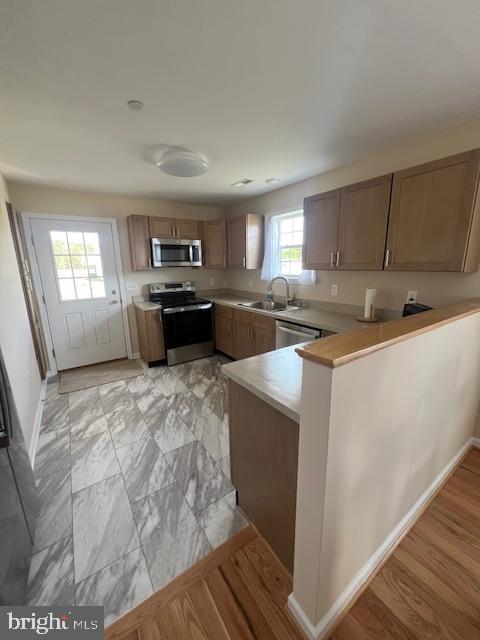 2287 Waterview Dr, Nanticoke, MD 21840 - kitchen with light countertops, a sink, baseboards, a peninsula, and appliances with stainless steel finishes