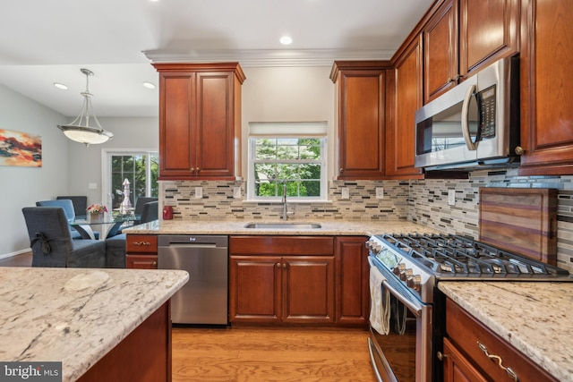 kitchen with backsplash, stainless steel appliances, a healthy amount of sunlight, and a sink