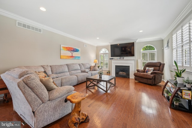 living area with plenty of natural light, a fireplace, visible vents, and hardwood / wood-style flooring