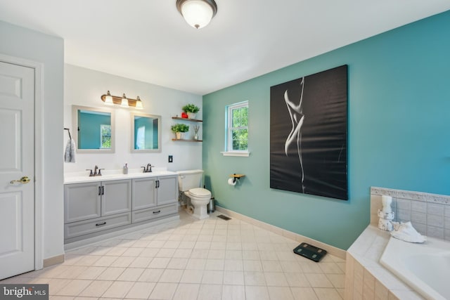 bathroom featuring double vanity, a relaxing tiled tub, a sink, baseboards, and toilet
