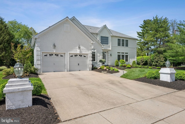 view of front of house with stucco siding, driveway, and a garage
