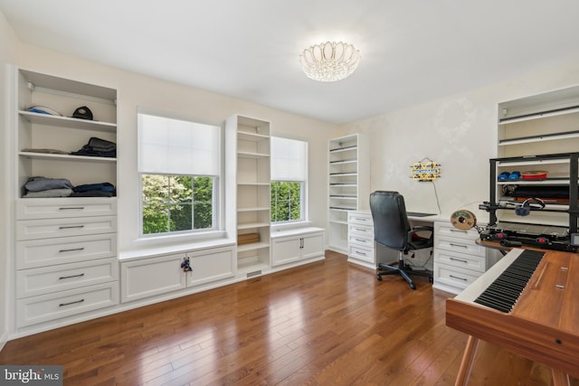 home office featuring dark wood-style floors and built in shelves