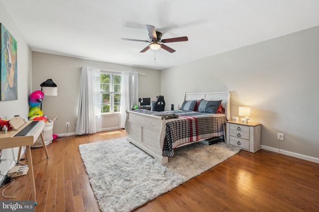 bedroom featuring baseboards, a ceiling fan, and wood finished floors