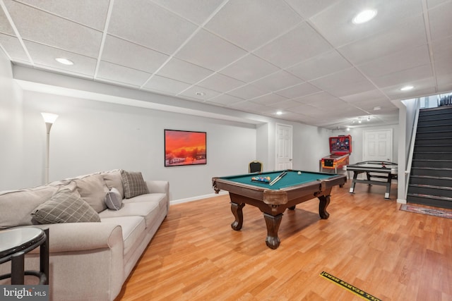game room featuring baseboards, a paneled ceiling, and light wood-style flooring
