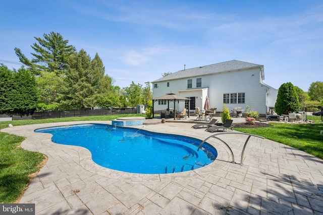 view of swimming pool with a gazebo, a pool with connected hot tub, a fenced backyard, and a patio area