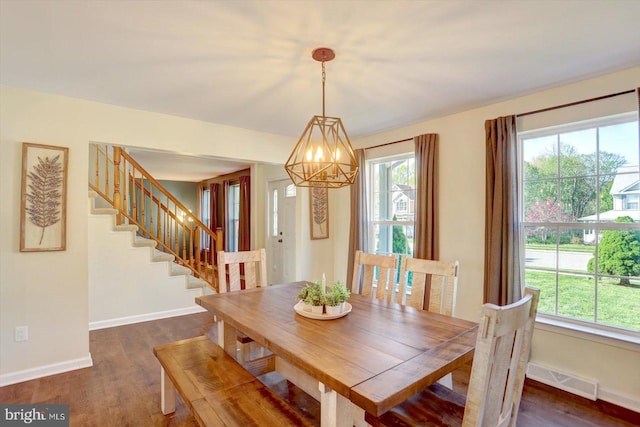 dining area featuring baseboards, visible vents, dark wood finished floors, and a chandelier