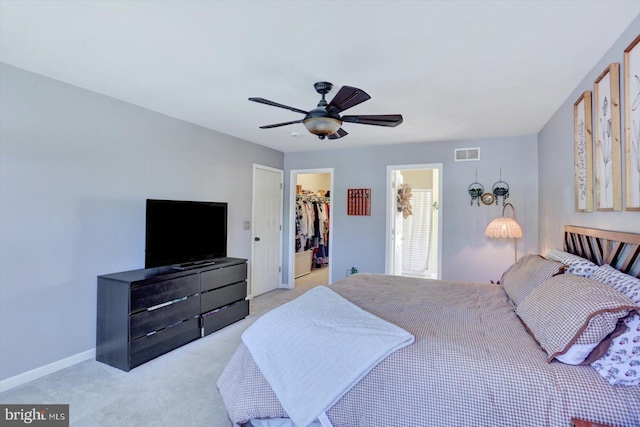 bedroom featuring visible vents, a closet, light carpet, ceiling fan, and a spacious closet