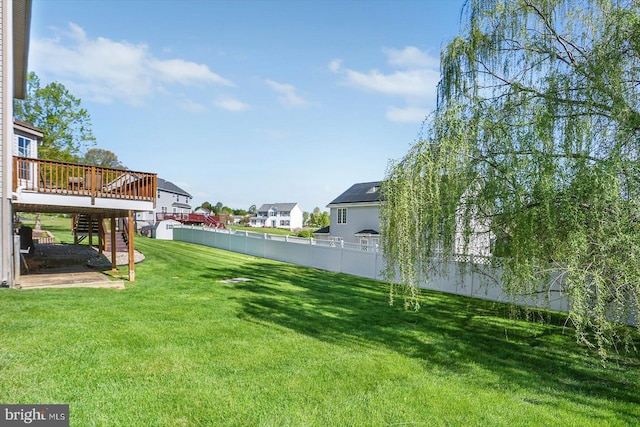 view of yard with fence, a deck, stairway, and a residential view