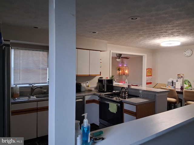 229 Old Line Ave, Laurel, MD 20724 - kitchen with electric range, white cabinets, a textured ceiling, ceiling fan, and a sink