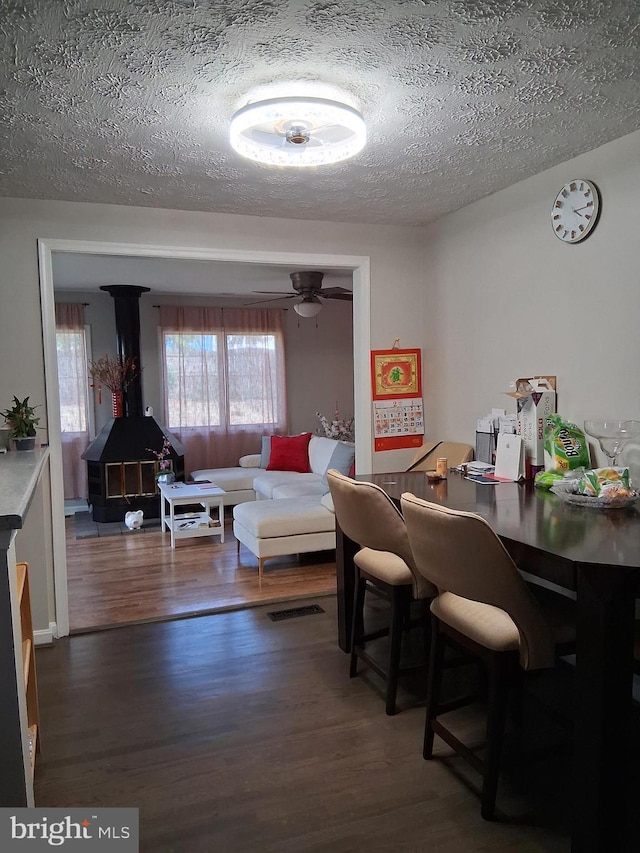 229 Old Line Ave, Laurel, MD 20724 - dining space featuring a textured ceiling, wood finished floors, a wood stove, and a ceiling fan