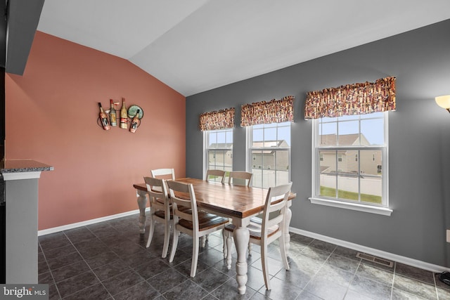 dining area with lofted ceiling, baseboards, and visible vents